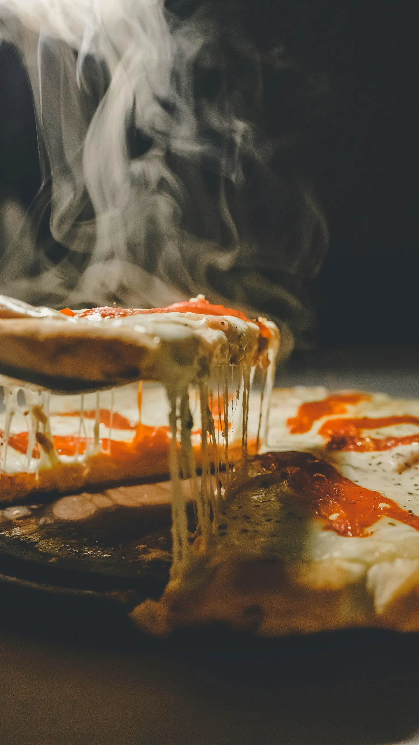 Pizza humeante recién salida del horno con queso fundido