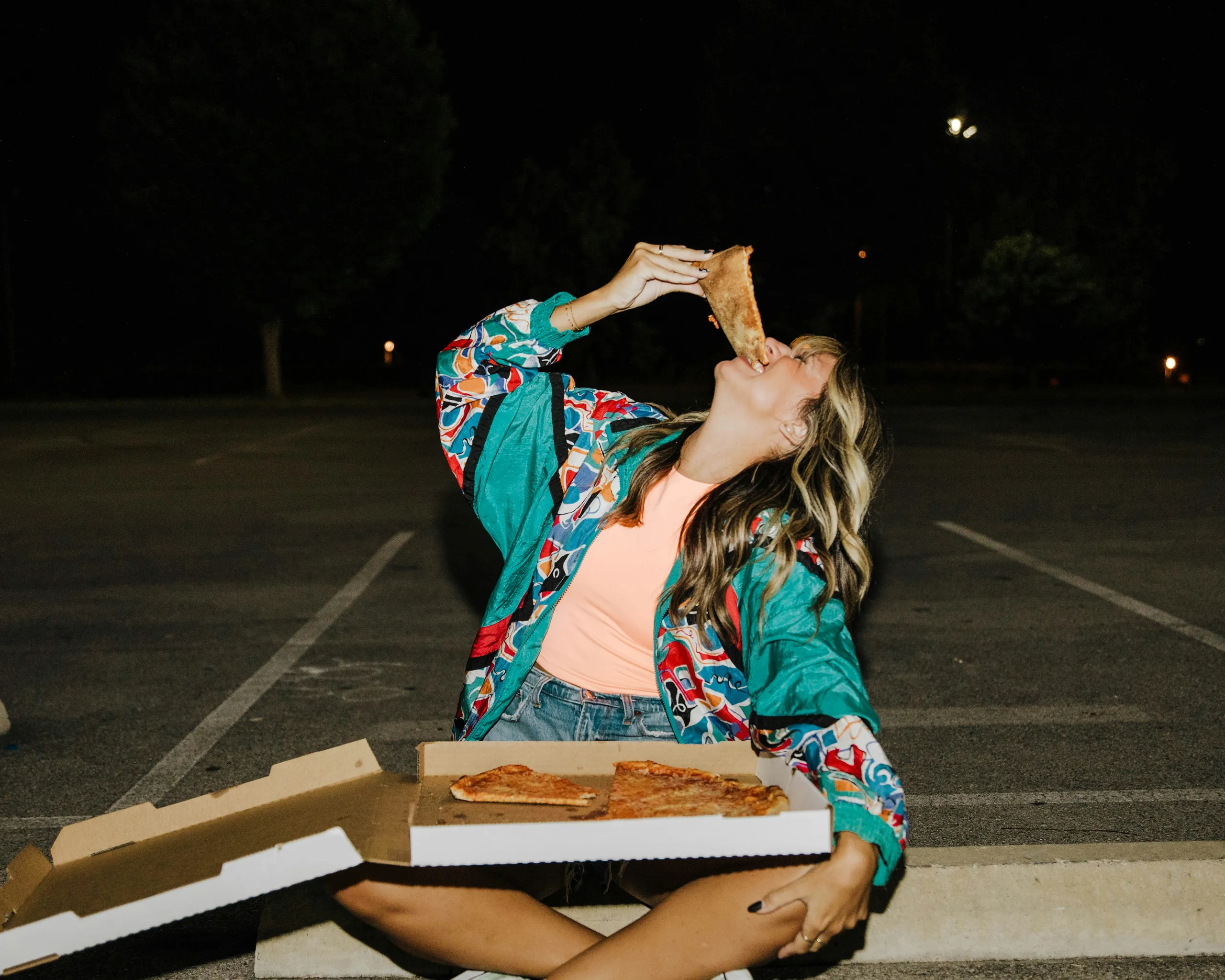 Empleado con delantal sosteniendo una pizza recién hecha